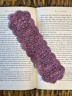 an open book with a crocheted object on it