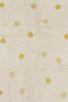 a white and yellow rug with gold dots on the top in an area that looks like it has been cleaned