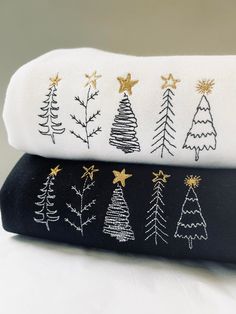 two black and white towels with gold christmas trees on them, one is folded over the other