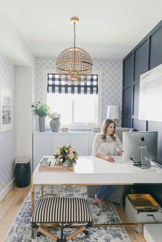 a woman sitting at a desk in front of a laptop computer on top of a rug