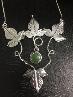 I've fabricated four sterling silver Elvish-inspired woodland Ivy leaves and vine work to surround a center and movable, 8mm gemstone of your choice set within the necklace pendant! This piece is approximately 3 inches in depth and 2 3/4 inches across. Each are hand-made so subtle variances will occur in the fabrication of the pendant but it will still have the look of the one shown above. The center stone is hinged so it has movement to bring light and life to the piece...and it creates fun to Nature-inspired Sterling Silver Wire Wrapped Jewelry, Nature-inspired Sterling Silver Wire Wrapped Necklaces, Nature-inspired Wire Wrapped Sterling Silver Necklaces, Hand Forged Silver Necklaces In Nature-inspired Style, Hand Forged Silver Nature-inspired Necklace, Hand-forged Silver Nature-inspired Necklace, Silver Wire Wrapped Nature-inspired Jewelry, Silver Nature-inspired Wire Wrapped Jewelry, Sterling Silver Nature-inspired Cabochon Necklace