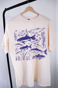 Vintage 90s Tattoo Fish Shirt ⭐ Welcome to K & K Custom Tees! ⭐  - Indulge in pure comfort with our Comfort Colors Shirt. Soft, relaxed, and available in a variety of colors! ⭐SHIRT DETAILS⭐  -High Quality fabric  -100% ring-spun US cotton -Designed and printed in the USA  ⭐ PLEASE NOTE ⭐ -For an oversized look, we suggest to size up 1-2 sizes. These shirts run like standard unisex tees. Please see size chart for a more fitted look!  -Colors may vary based on your monitor or screen display! ⭐CAR Cotton Short Sleeve Top With Fish Print, Short Sleeve Cotton Shirt With Fish Print, Cotton Short Sleeve Shirt With Fish Print, Cotton Short Sleeve T-shirt With Fish Print, Graphic Tee With Fish Print And Crew Neck, Graphic Tee T-shirt With Fish Print, Graphic Fish Print Short Sleeve T-shirt, Graphic Fish Print T-shirt With Short Sleeves, Fish Print Crew Neck Graphic Tee