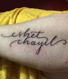 a person with a tattoo on their arm that says, eshet chayll