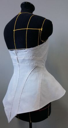 a mannequin wearing a black and white dress with yellow lines on the back