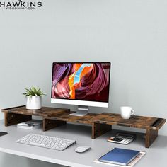 a computer monitor sitting on top of a wooden desk next to a keyboard and mouse