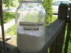 a jar filled with sugar sitting on top of a wooden fence