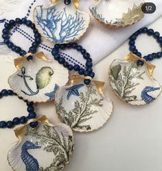 six seashells with blue beads are sitting on a table