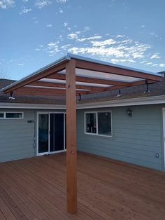 a wooden deck with an attached pergolan on the top and side of it