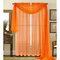 an orange sheer curtain hanging in front of a window