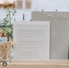 the bar sign is next to some wooden utensils and flowers in a vase