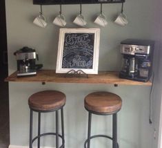 two stools sit at the top of a bar with a chalkboard sign above it