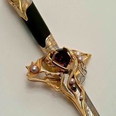 a pen with a fancy design on it and a jewel in the top part, sitting on a table