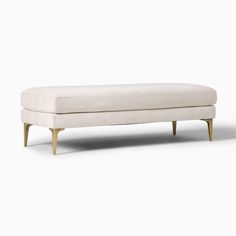 an upholstered bench with wooden legs and a white fabric cover on the back