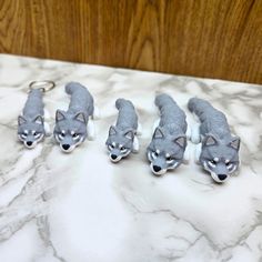 five wolf key chains on a marble surface