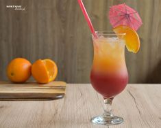 an orange and red drink sitting on top of a wooden table