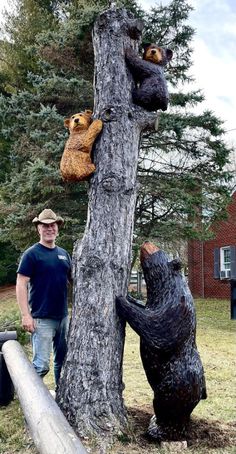 a man standing next to a tree with stuffed bears on it