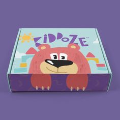 a box with an image of a pink bear on the front and bottom, sitting in front of a purple background