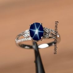 This Ring Features a 6X8 MM Oval Cabochon Natural Blue Lindy Star and Sterling Silver Finished with rhodium. Customization is available. It is made by hand, and it will take about 3 to 5 business days to finish the ring after your payment is completed. Product Description Main stone: Natural Blue Lindy Star Metal type: 92.5 Sterling Silver finished with rhodium Accent stone: Zircon How To take care of This Ring - Keep the jewelry away from direct heat, water, perfumes, deodorants, and other stro Blue Star Ring, Silver Star-shaped Gemstone Ring, Silver Star-shaped Ring With Gemstone, Star Shaped Sapphire Ring For Anniversary In Sterling Silver, Star-shaped Silver Sapphire Promise Ring, Star-shaped Silver Sapphire Ring, Star-shaped Sterling Silver Sapphire Ring, Sterling Silver Star-shaped Sapphire Ring, Silver Star-shaped Sapphire Ring As Gift