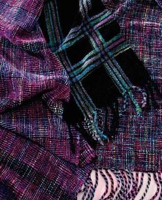 a purple and black plaid scarf laying on top of a table