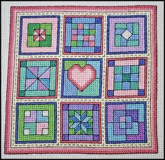 a cross stitch quilt with squares and hearts on it