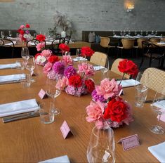 the table is set with flowers and place cards for guests to sit down at it