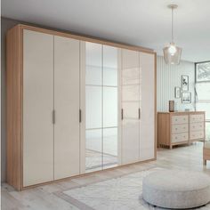 a bedroom with white and wood furniture and a large mirror on the wall above it