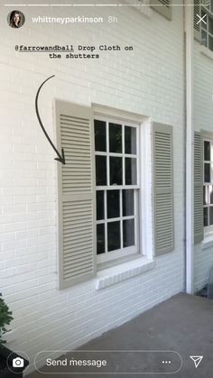 a white brick building with shutters open