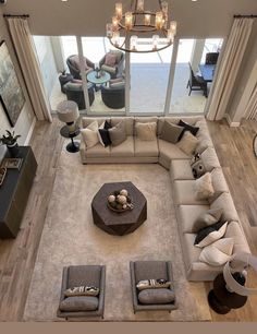 an aerial view of a living room with couches, tables and chandelier