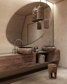 a bathroom with two sinks and a large round mirror