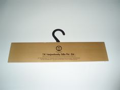 an open cardboard box with a black handle hanging from it's side on a white wall