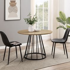 a dining room table with two chairs and a plant