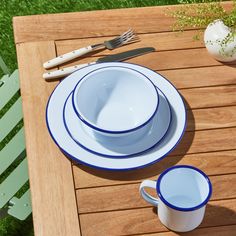 a wooden table topped with white and blue dishes