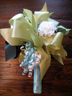 a bridal bouquet with green and white flowers on a wooden table next to a pair of scissors