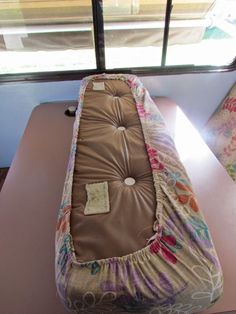 a baby crib in front of a window on a table next to a couch