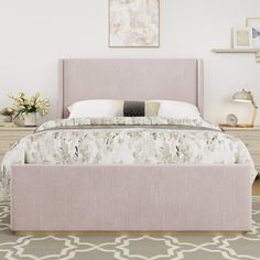 a bed with a pink headboard and foot board in a white room next to a rug