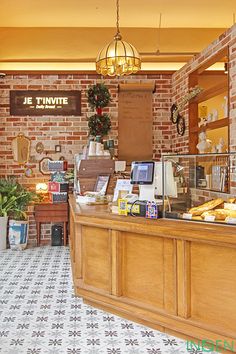 the interior of a restaurant with brick walls and tiled flooring, along with an open counter