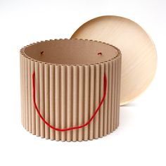 a round object with a red string on it's side and a cardboard box in the background