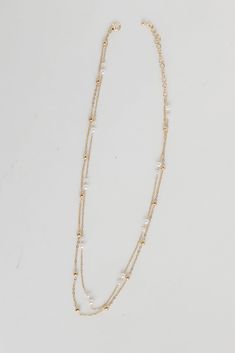 The Brooke Gold Pearl Layered Chain Necklace is the simplest way to make any look even more darling! This trendy necklace features two layers of gold chains with pearls. Style the Brooke Necklace with any outfit to instantly upgrade your look! Gold Plated Layered Pearls Lobster Clasp with Extender Layer 1 | Length 7.5" Layer 2 | Length 7" Extender | Length 3" Gold Pearl Multi-strand Layered Necklace, Gold Multi-strand Pearl Layered Necklace, White Pearl Double Chain Necklace, Gold Pearl Necklace For Layering, White Double Strand Pearl Chain Layered Necklace, Gold Pearl Double Chain Necklace, Double Strand Gold Chain Necklace With Pearl Charm, Gold Double Strand Chain Necklace With Pearl Charm, Dainty Double Strand Pearl Chain Layered Necklace