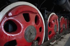 red and white train wheels sitting on the tracks