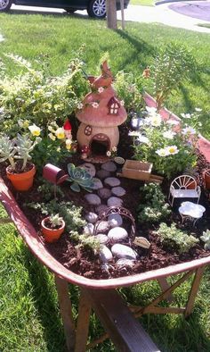 a wheelbarrow filled with lots of plants and rocks