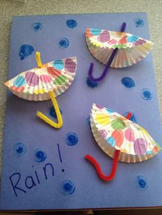 some paper umbrellas are sitting on top of a blue mat with writing underneath them