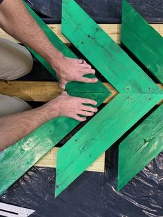 two men are working on some green wood