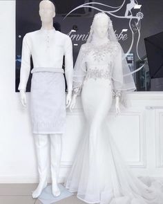 two mannequins dressed in white and one wearing a wedding dress with long sleeves