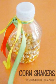 corn shakers in a glass jar with ribbon around the top on an orange table