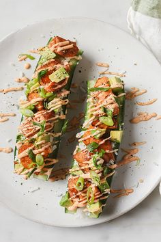 a white plate topped with cucumber slices covered in toppings