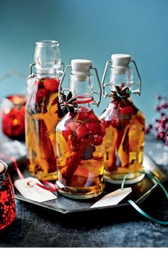 three bottles filled with liquid sitting on top of a tray next to some candy canes