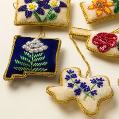 embroidered ornaments are displayed on a white surface