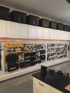 there are many hats hanging on the wall in this garage with tools and other items