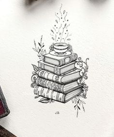 a stack of books sitting on top of a table next to a pen and ink