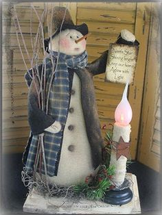 a snowman holding a lit candle with writing on it